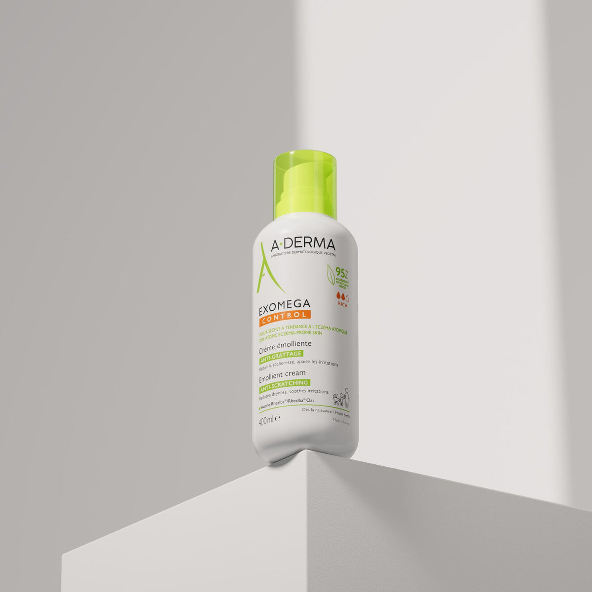 A-Derma Exomega Control, pump bottle standing on the corner of a white block