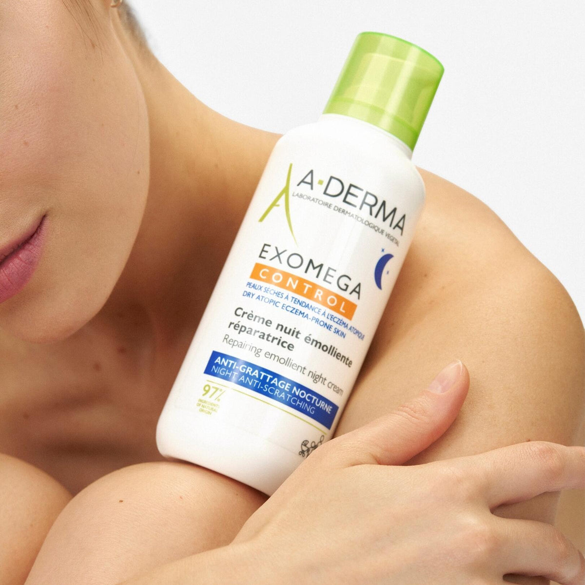 A-Derma Exomega Control, woman holding the pump bottle against her shoulder