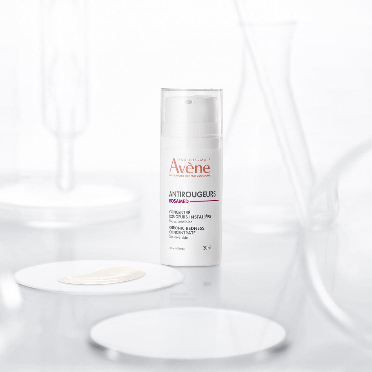 Avène Antirougeurs Rosamed, pump bottle among lab glassware with a cream sample