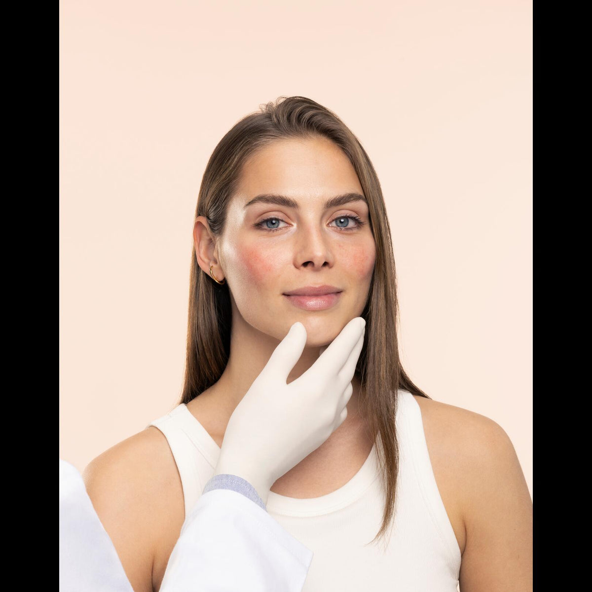 Avène Antirougeurs Rosamed, gloved hand under a woman's chin