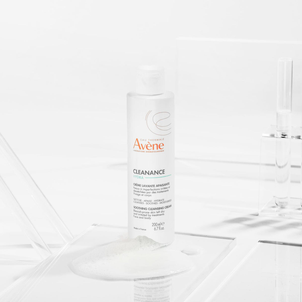 Avène Cleanance, bottle on clear acrylic blocks with a cream swatch