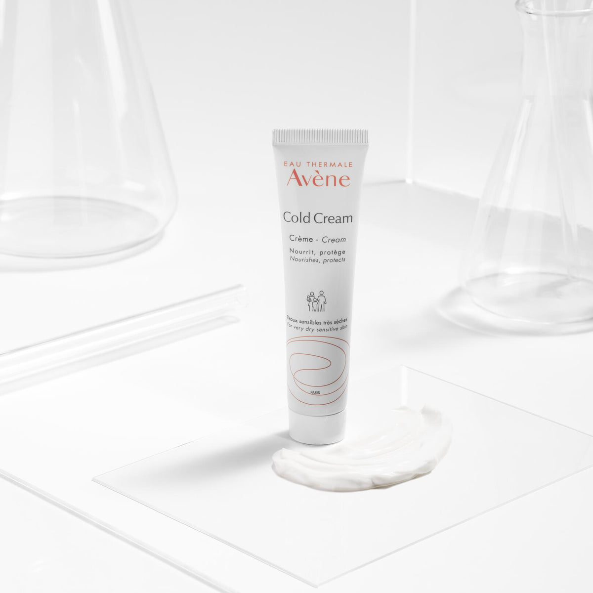 Avène Cold Cream, tube and cream swatch on a clear plate with glassware
