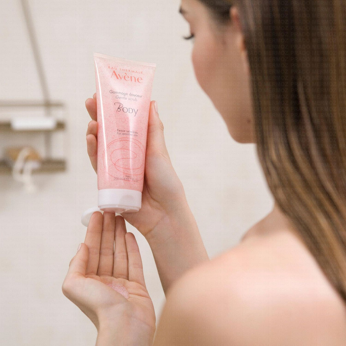 Avène Body, woman squeezing the scrub tube into her palm