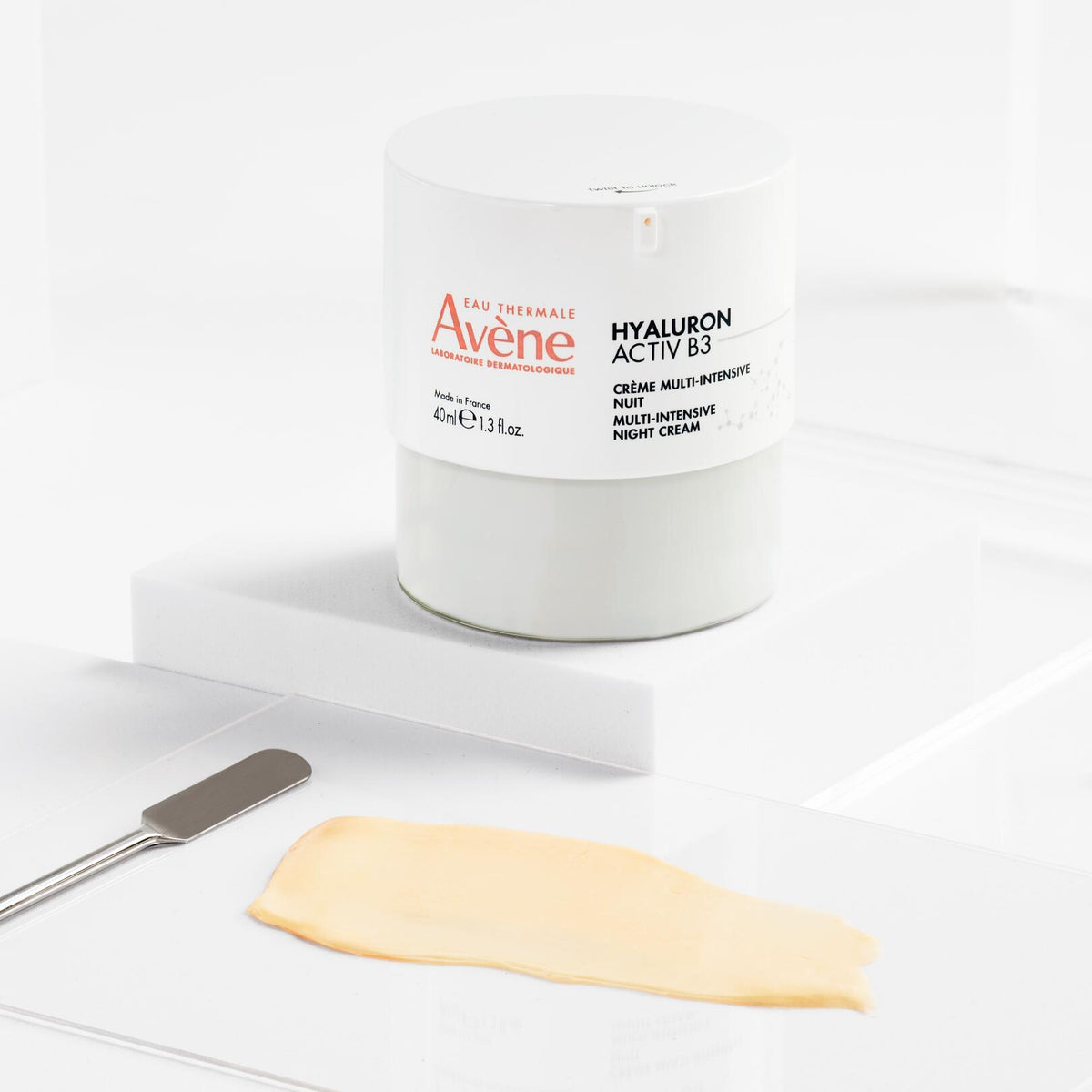Avène Hyaluron Activ B3, jar on a white block with a spatula and cream swatch