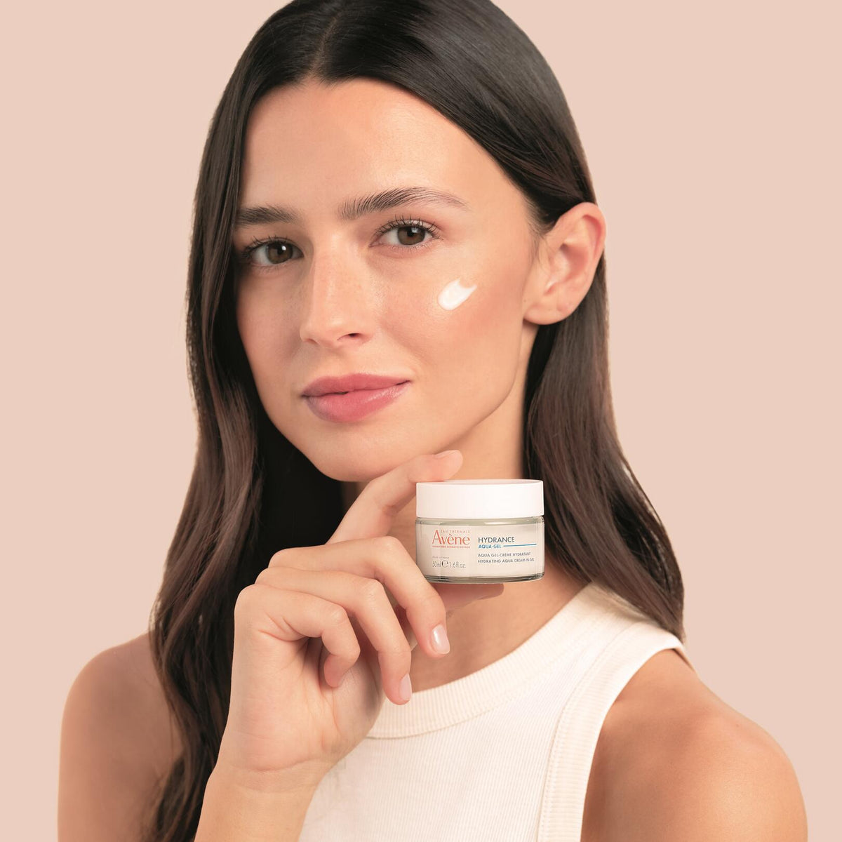 Avène Hydrance, woman holding the jar with cream on her cheek