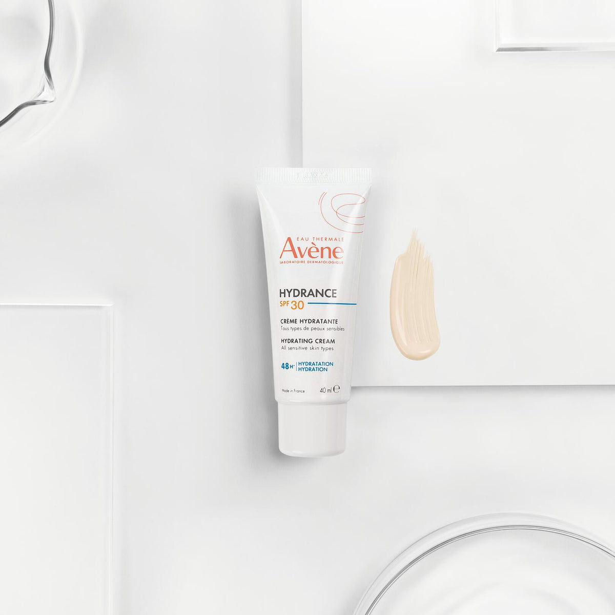 Avène Hydrance, tube beside a cream swatch on white blocks