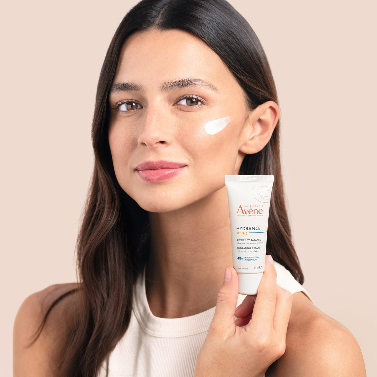 Avène Hydrance, woman holding the tube with cream on her cheek