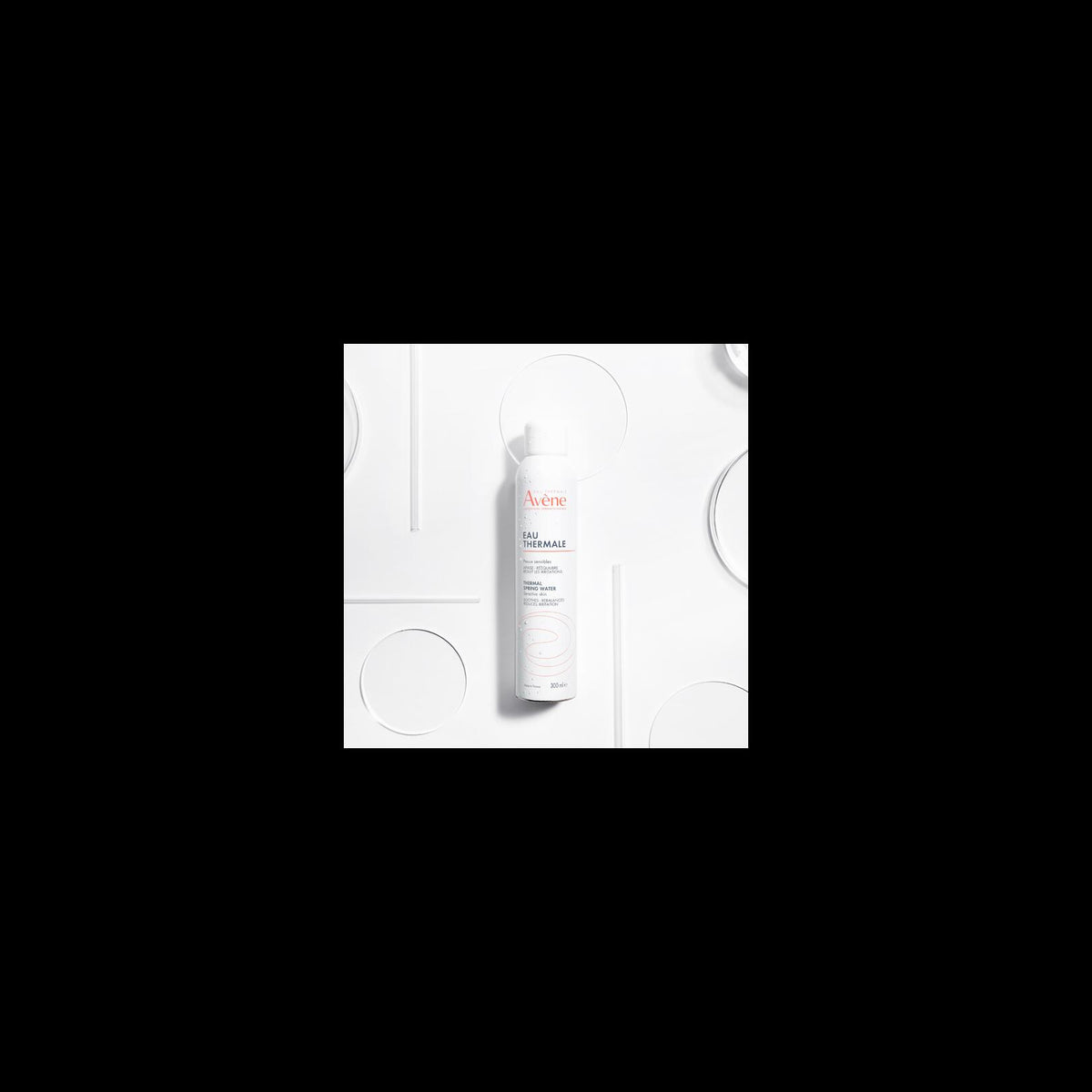 Avène Thermal Spring Water, spray can among glass discs, small in a black frame