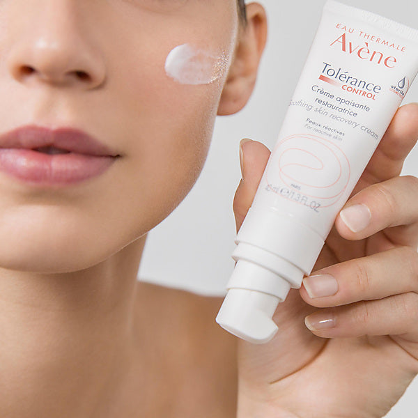 Avène Tolérance Control, woman holding the tube with cream on her cheek