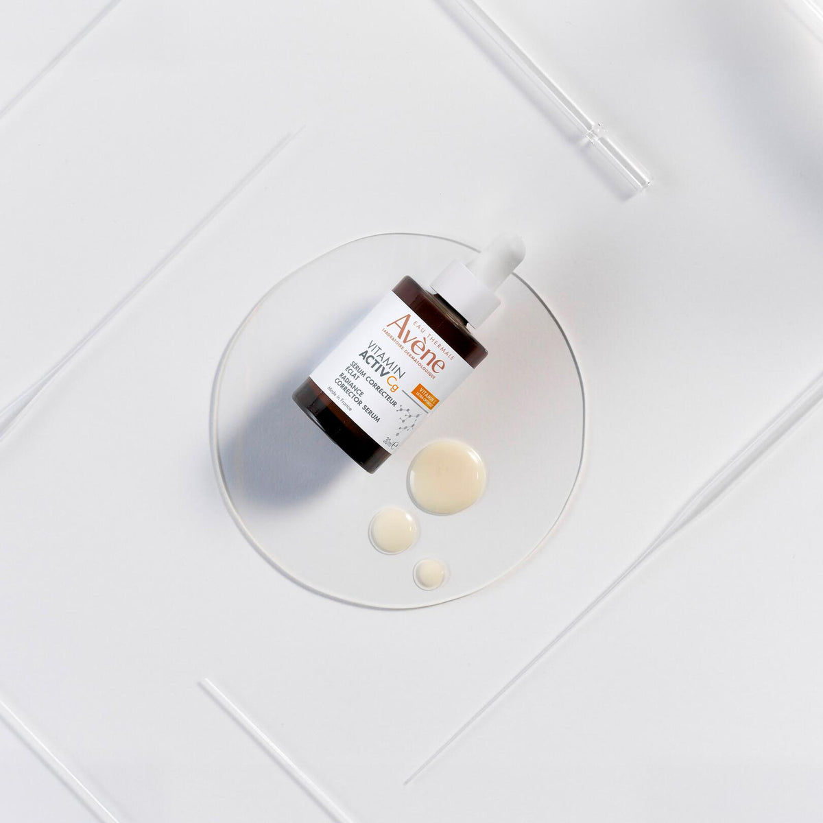Avène Vitamin Activ Cg, glass bottle on a glass dish with serum drops