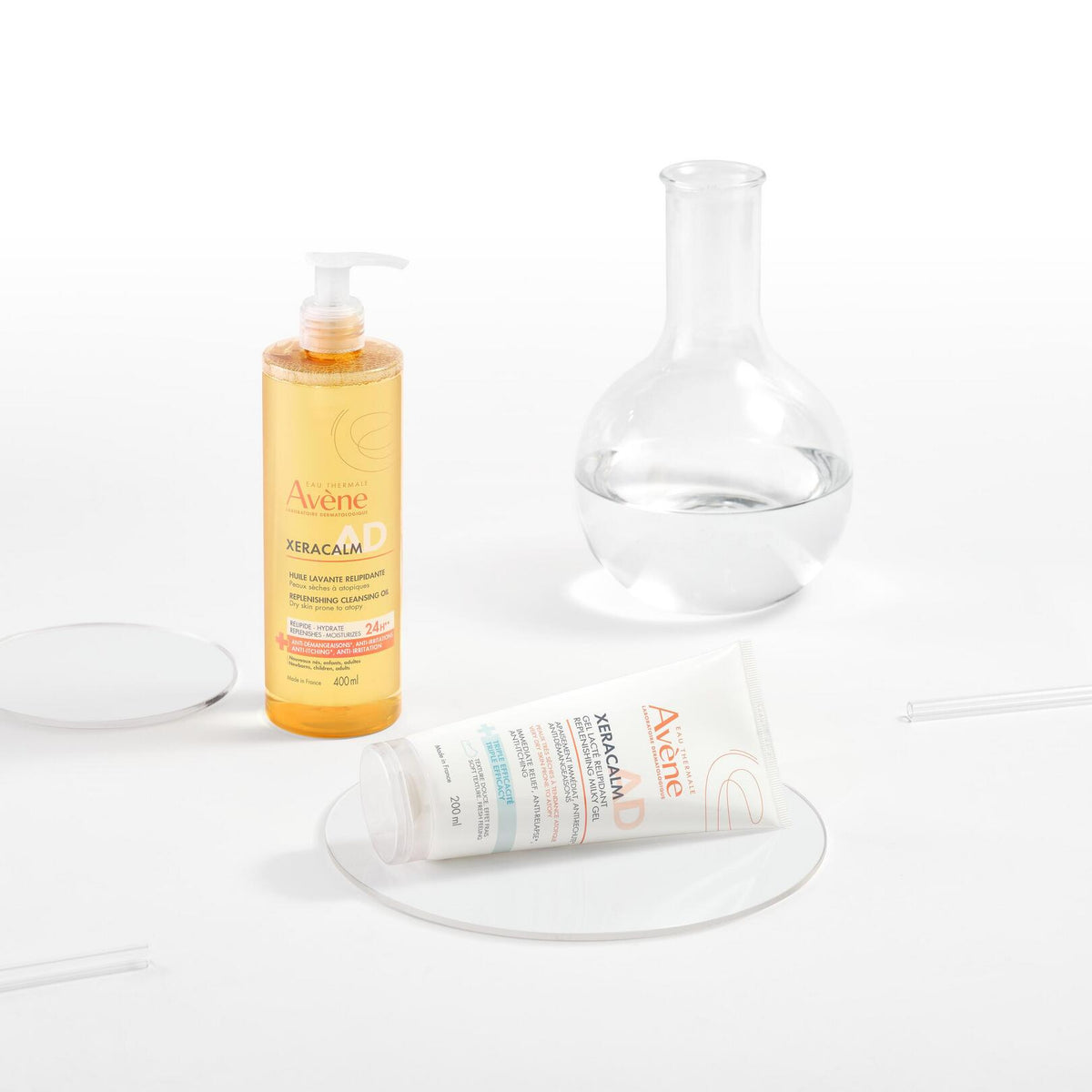 Avène XeraCalm AD, tube lying beside the cleansing oil pump bottle