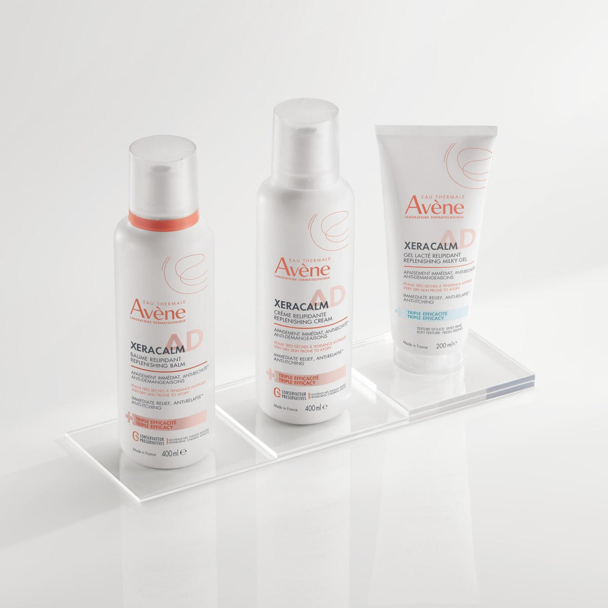 Avène XeraCalm AD, range of three products on a glass shelf