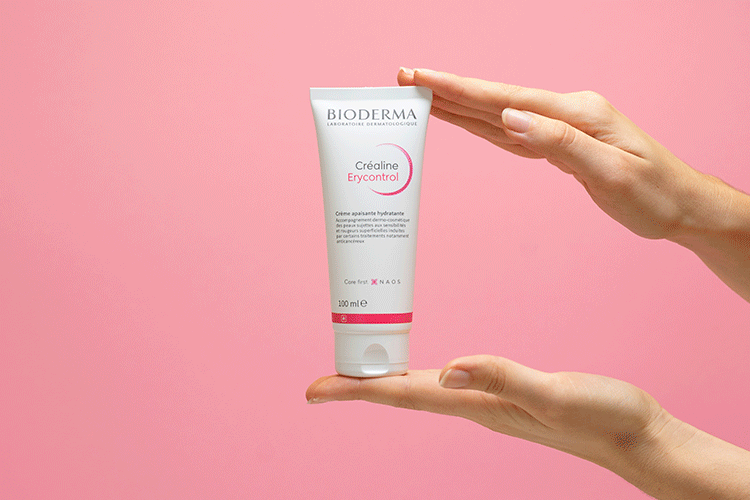 Bioderma Crealine Erycontrol, hands holding the tube on a pink background