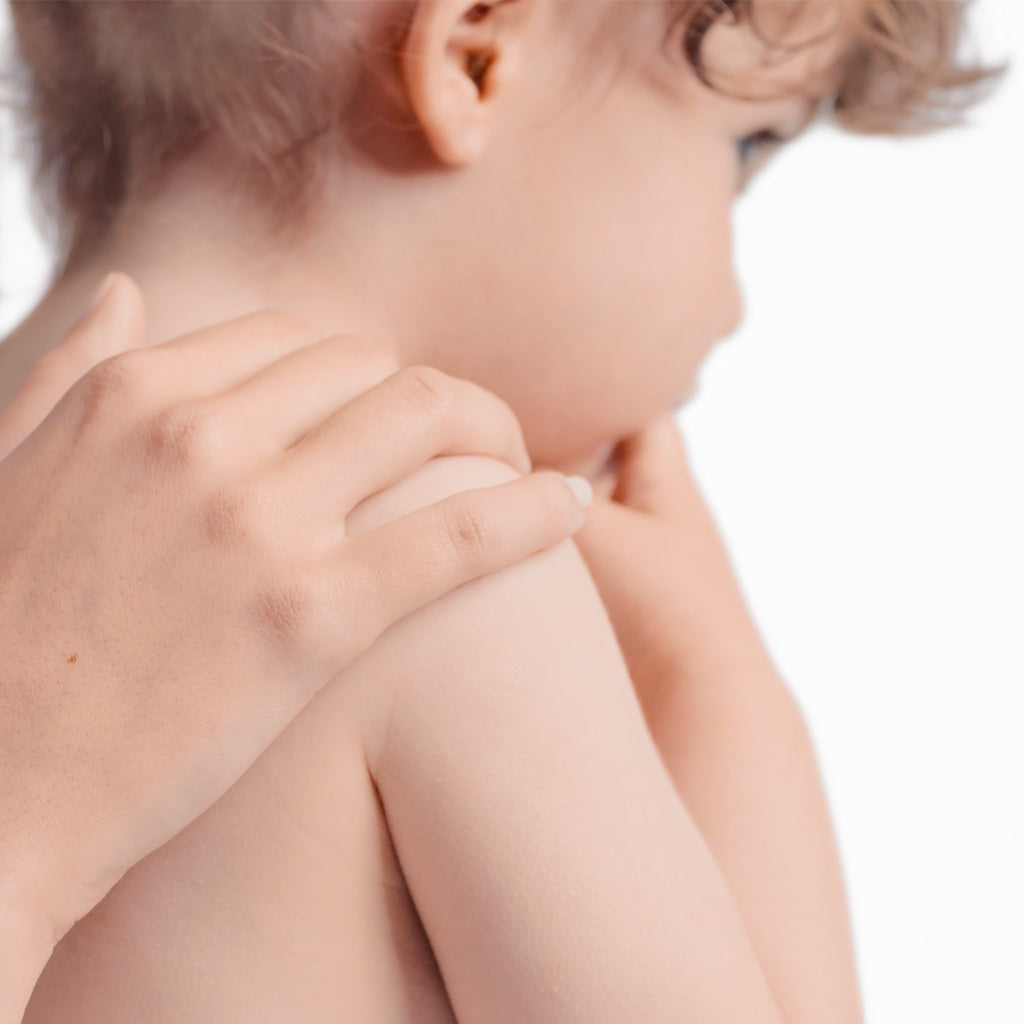 Bioderma Photoderm, adult hand on a toddler's bare shoulder