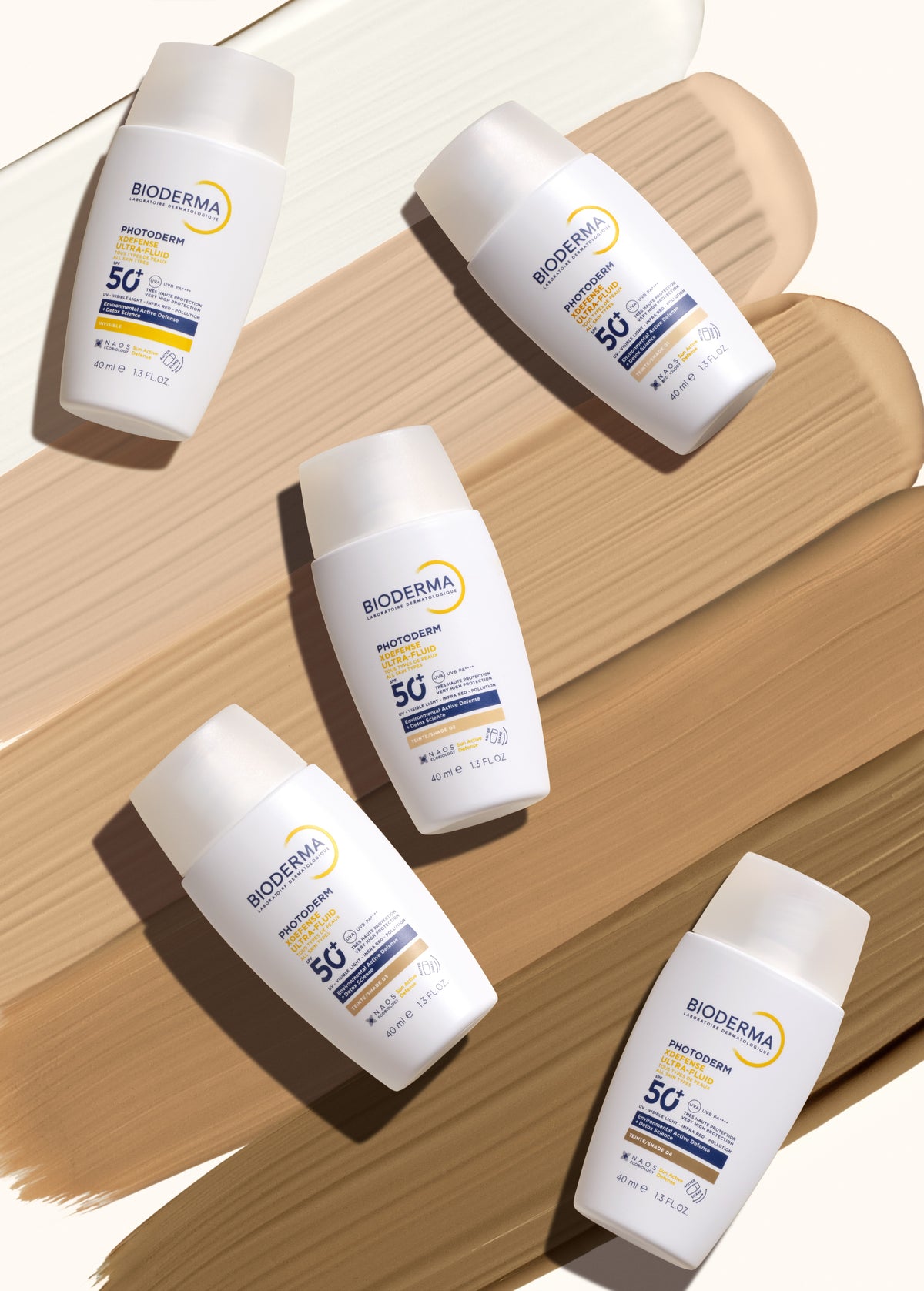 Bioderma Photoderm XDefense, five bottles on tinted fluid swatches