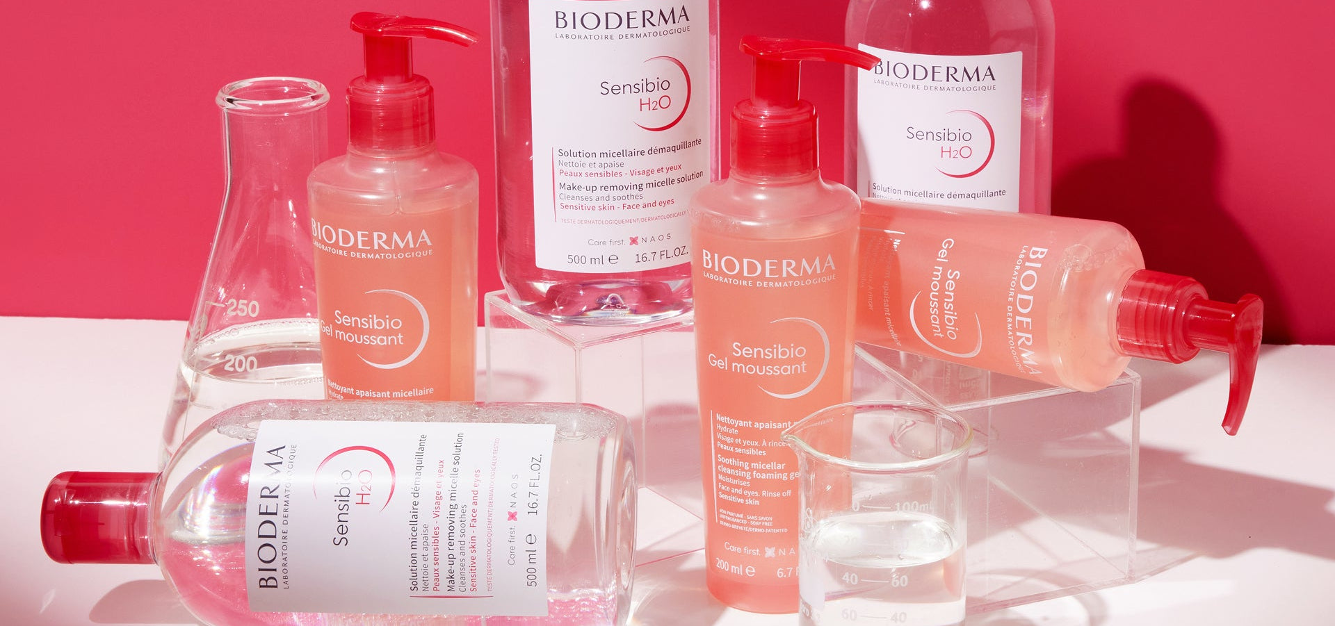 Bioderma skincare products on a white surface with a pink background