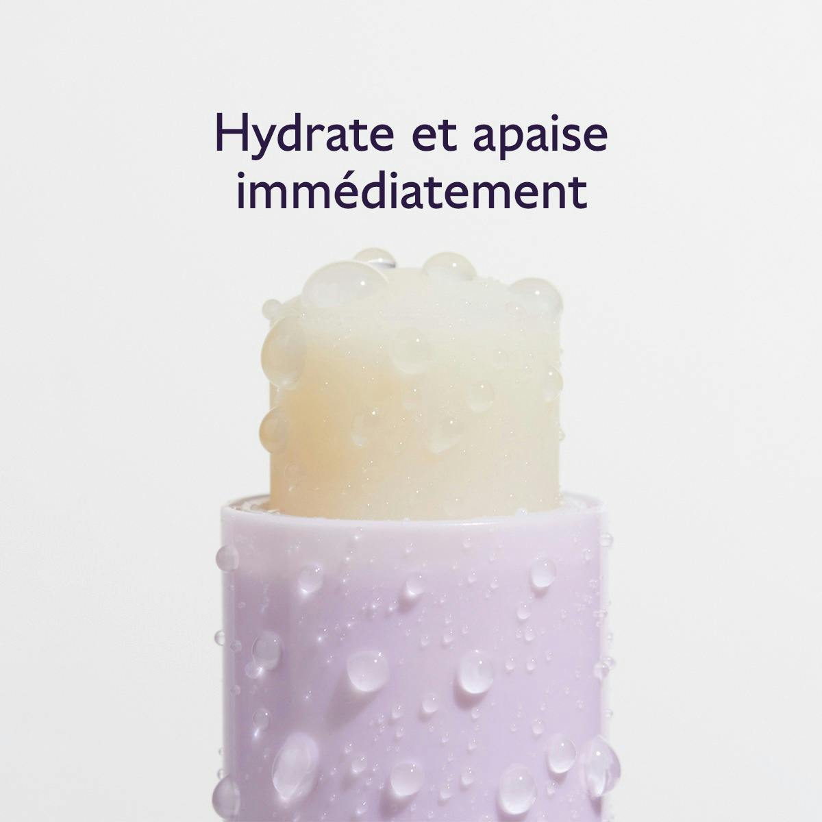 Caudalie Lip Care Stick, uncapped balm with water droplets, text in French