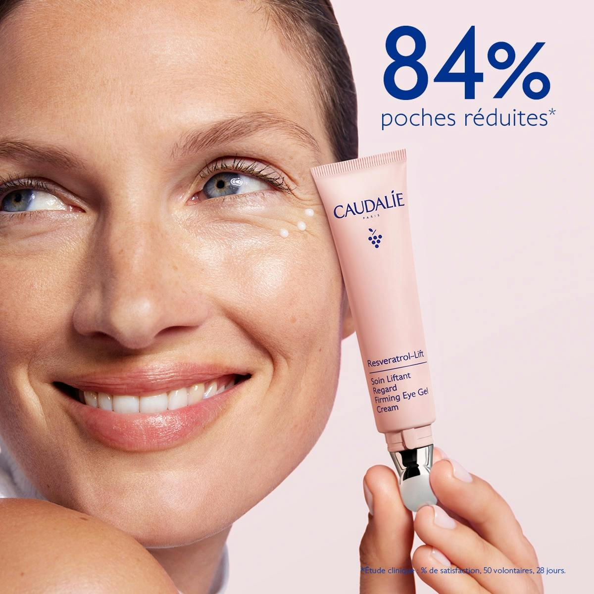 Caudalie Resveratrol-Lift, smiling woman holding the tube with dots of cream under her eye