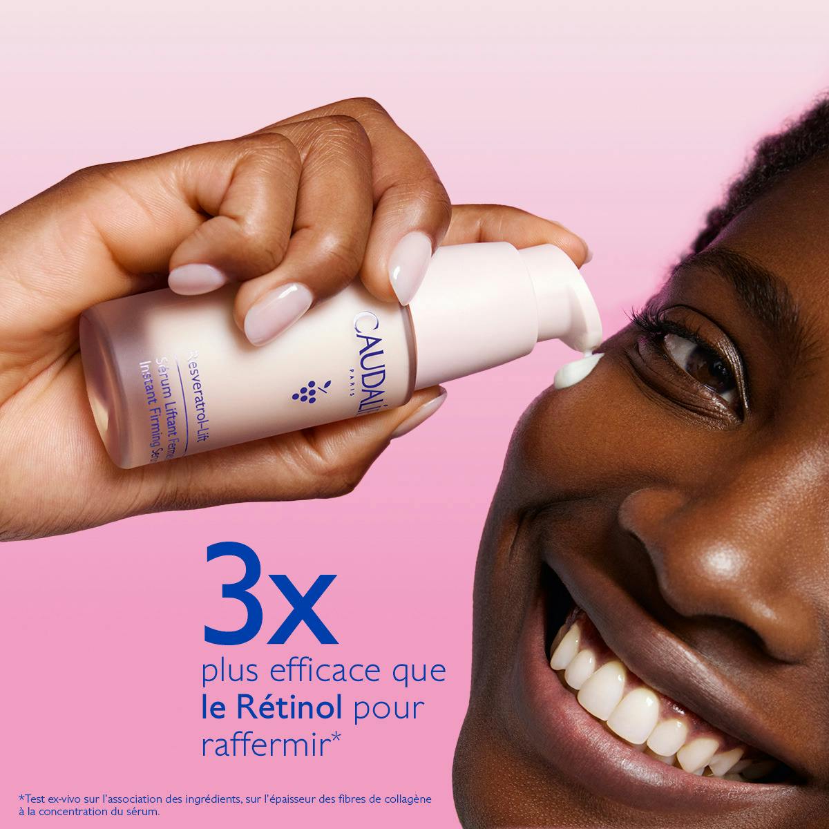 Caudalie Resveratrol-Lift, smiling woman pumping serum onto her cheekbone