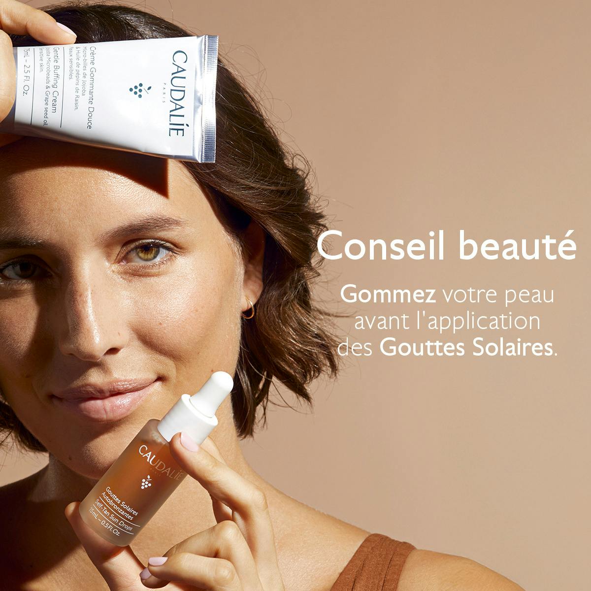 Caudalie Self-Tanning Sun Drops, woman holding a scrub tube and the dropper bottle