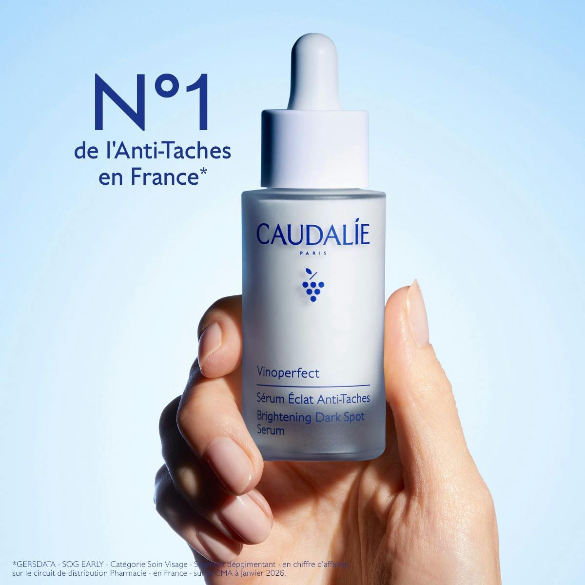 Caudalie Vinoperfect, hand holding the glass bottle, text in French