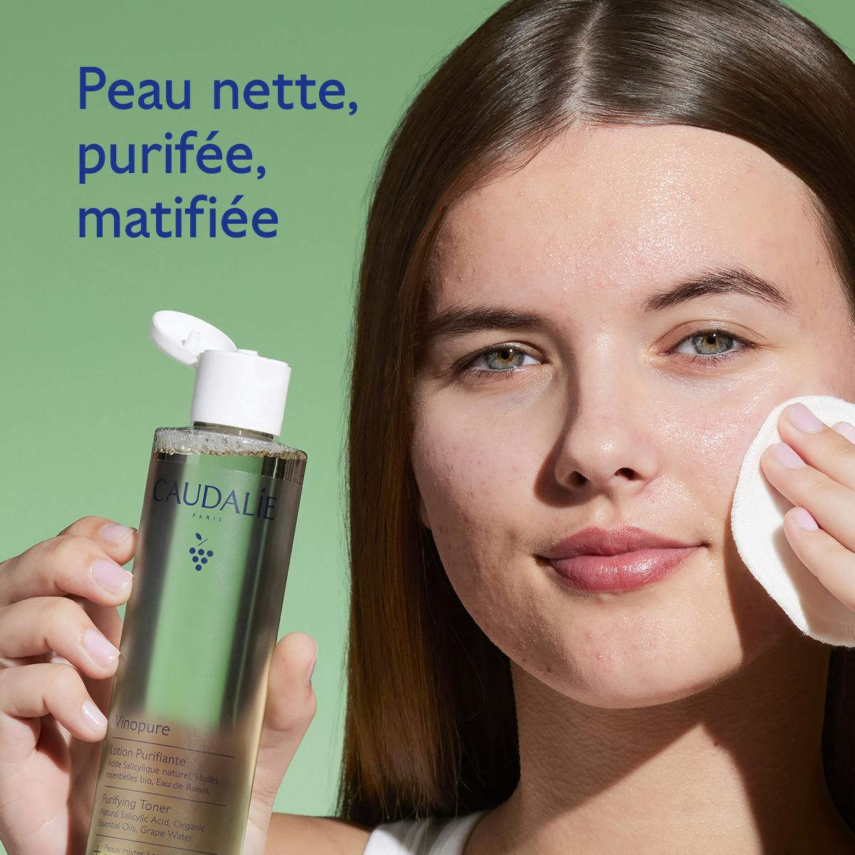 Caudalie Vinopure, woman holding the bottle and a cotton pad to her cheek