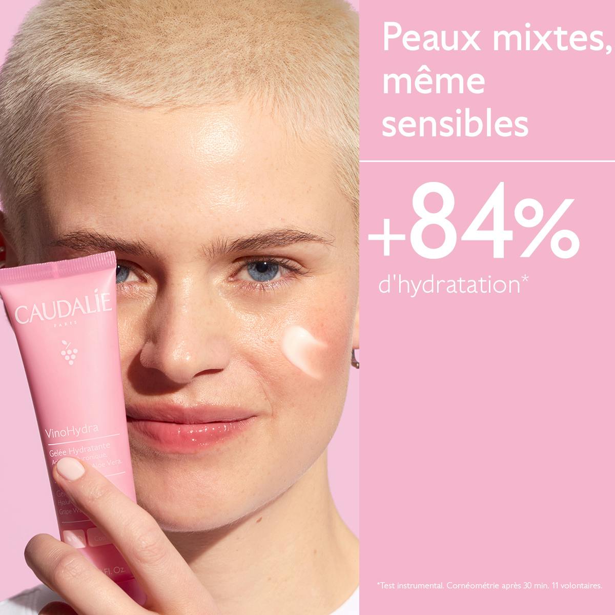 Caudalie Vinosource Hydra, woman holding the tube with a dab of gel on her cheek