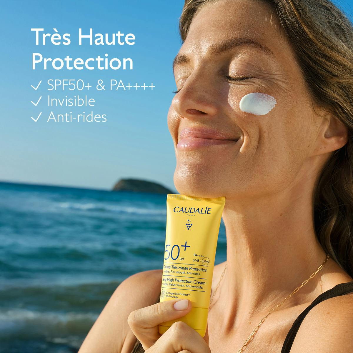 Caudalie Vinosun Protect, woman holding the tube with a dab of cream on her cheek