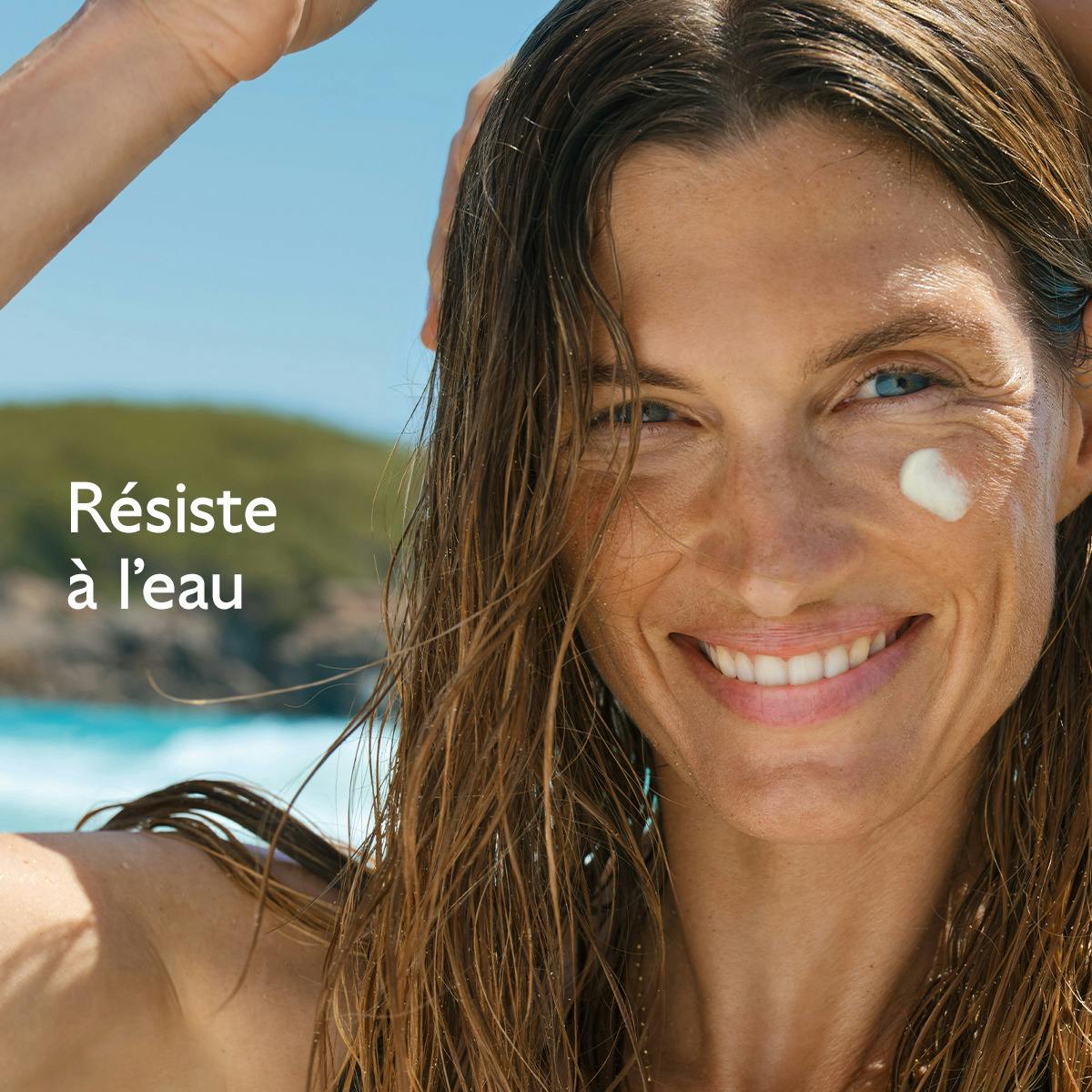 Caudalie Vinosun Protect, smiling woman with wet hair and cream on her cheek