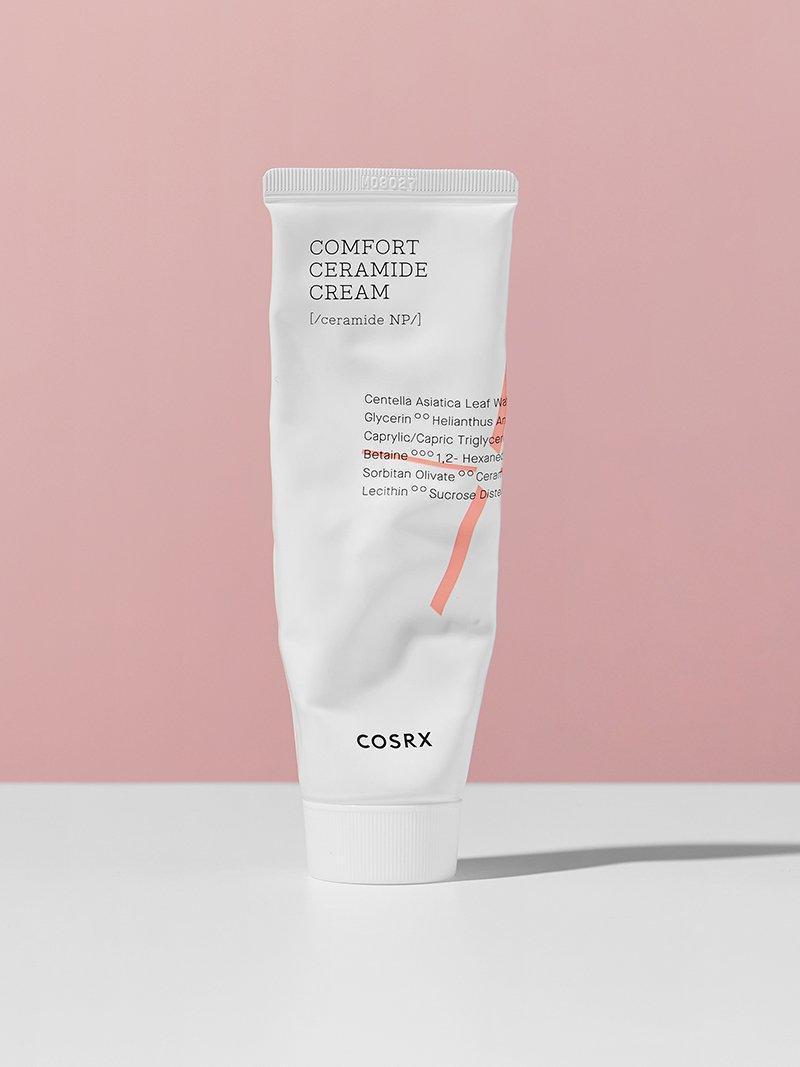 COSRX Balancium, tube standing against a pink wall