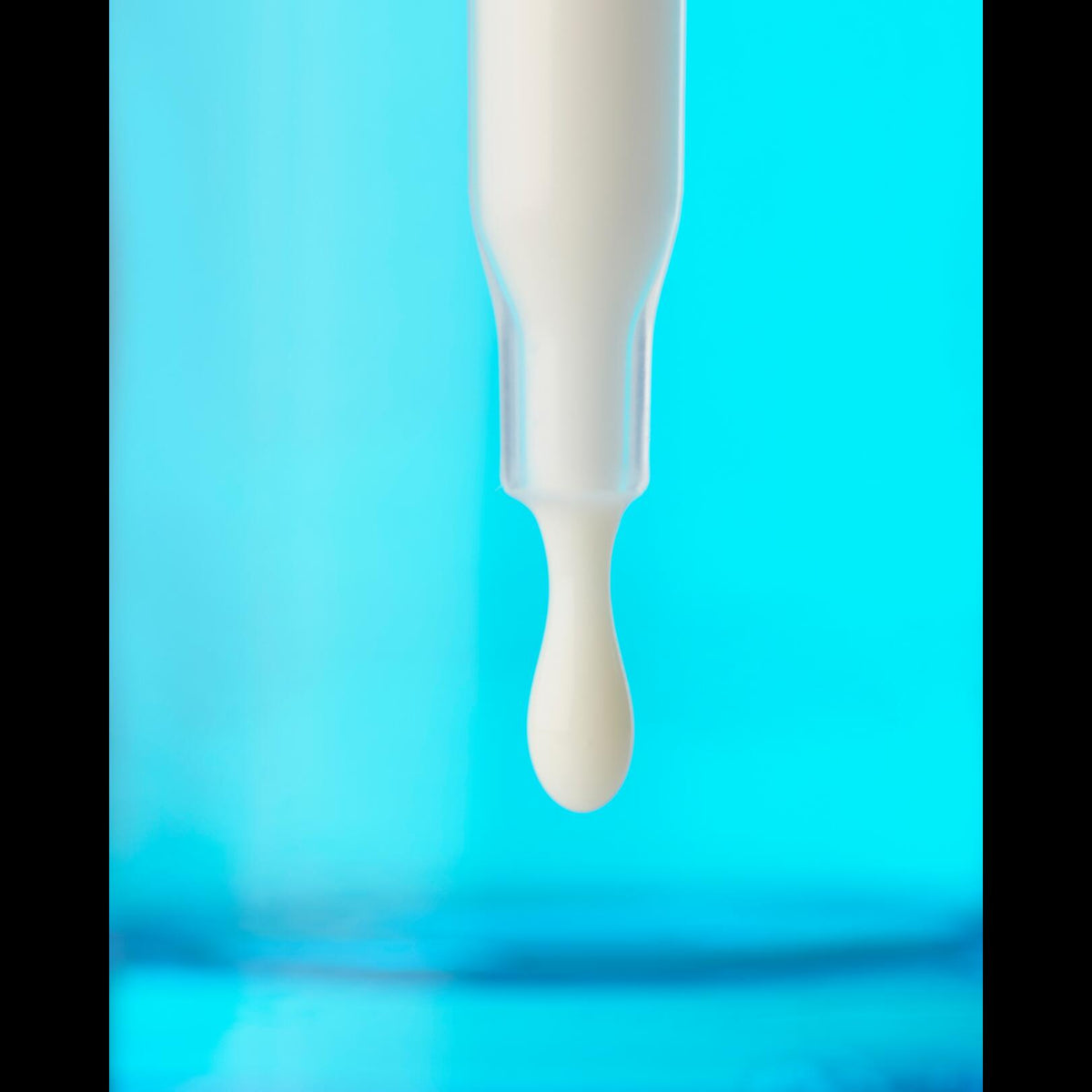 Ducray Keracnyl, dropper with a drop of serum on a blue background