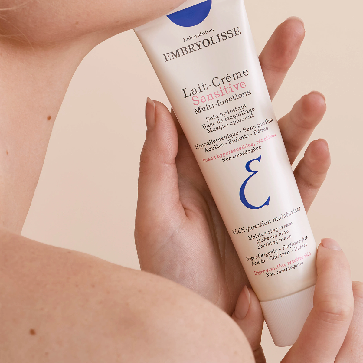 Embryolisse Sensitive Cream Milk, hands holding the tube against the shoulder