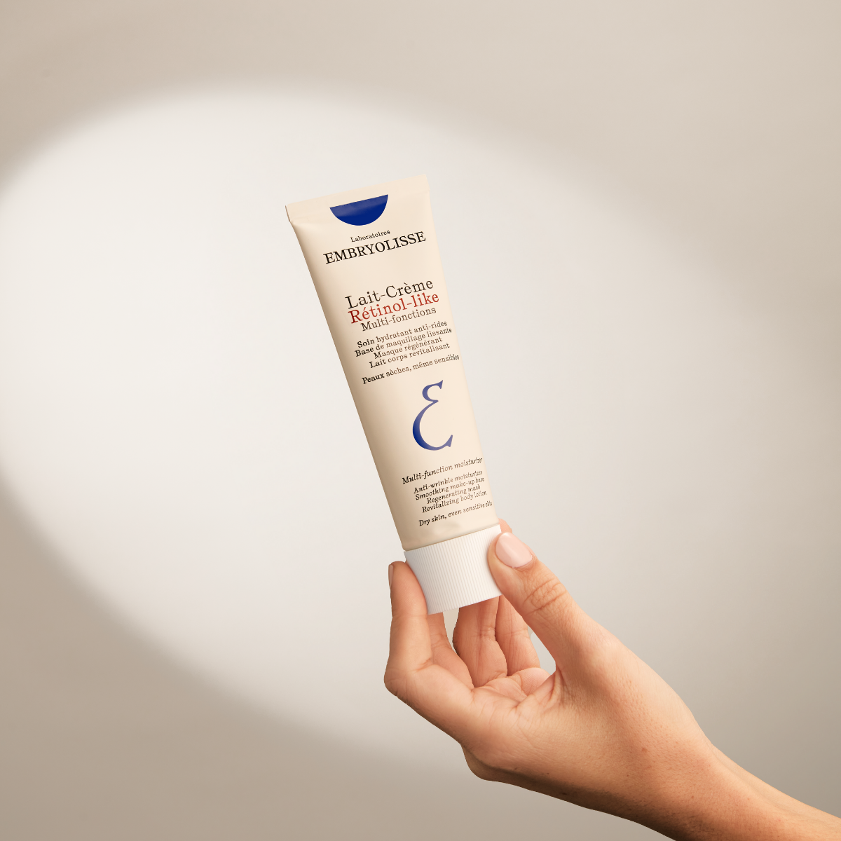 Embryolisse Retinol-Like Cream Milk, hand holding up the tube in a spotlight