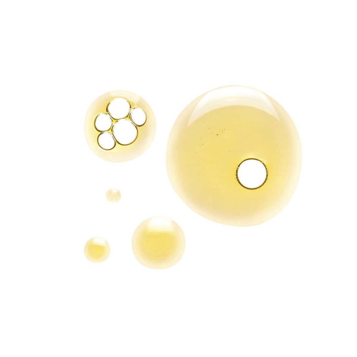 Klorane Mango, golden oil droplets on a white background