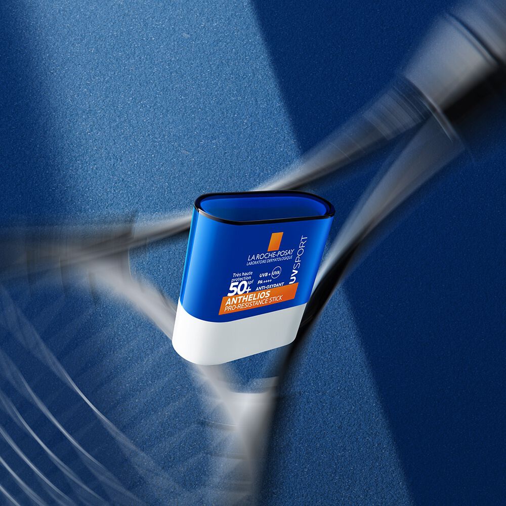 La Roche-Posay Anthelios, stick and tennis racket on a blue court