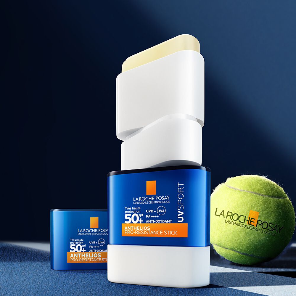 La Roche-Posay Anthelios, open stick beside its cap and a tennis ball