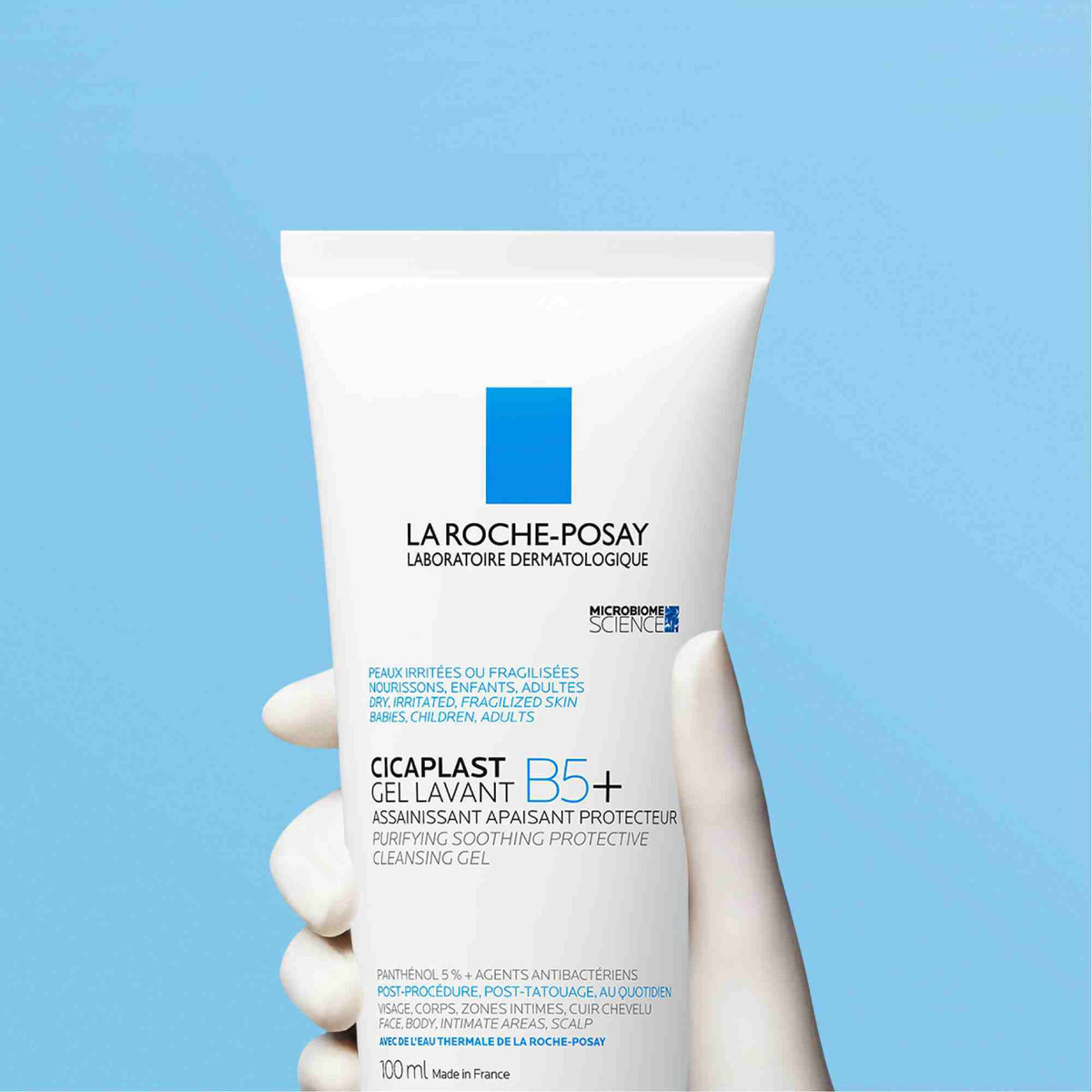 La Roche-Posay Cicaplast, gloved hand holding the tube on a blue background