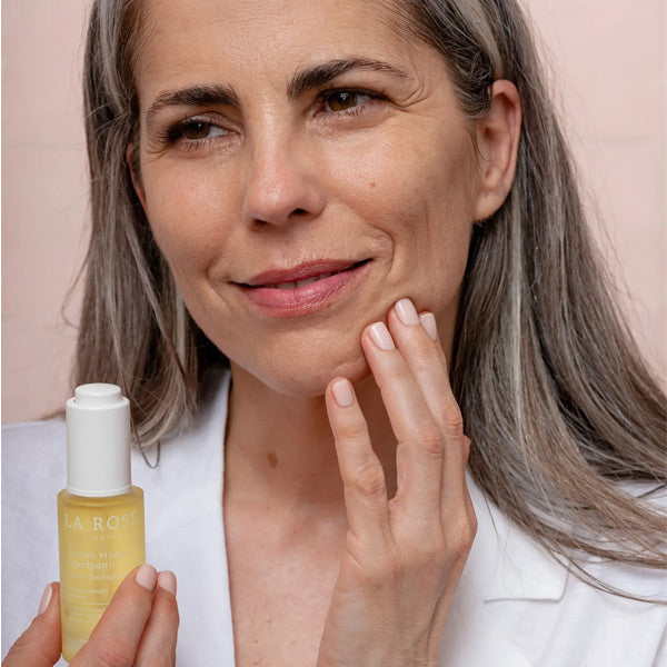 La Rosée Plumping Serum, smiling woman holding the bottle