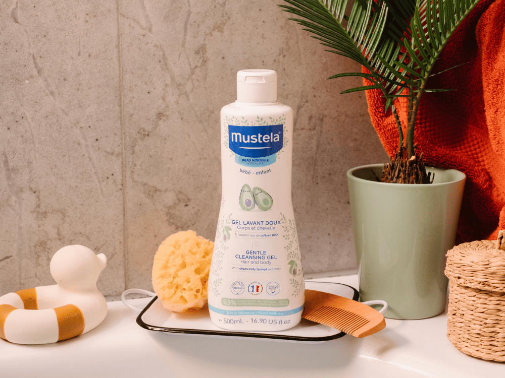 Mustela Body and Hair Wash, bottle on a tray with a sponge, rubber duck and comb