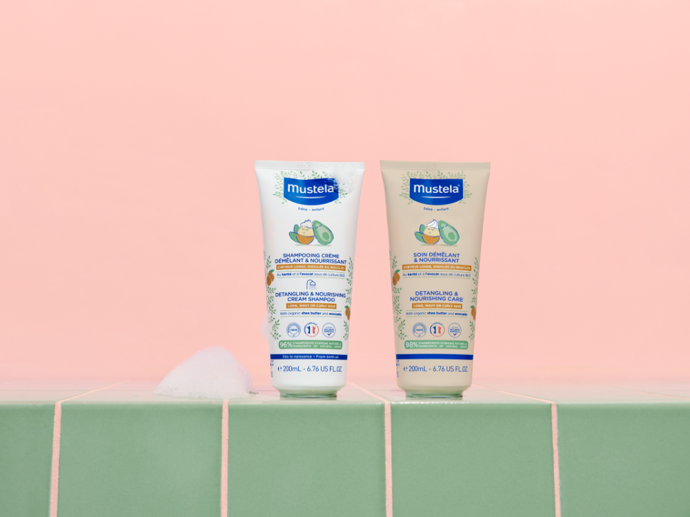 Mustela Detangling & Nourishing Care, care and cream shampoo tubes on green tiles