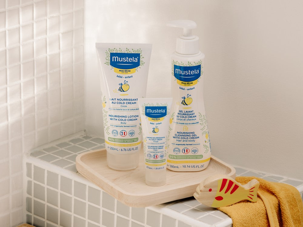 Mustela Cold Cream, range of three products on a wooden bath tray