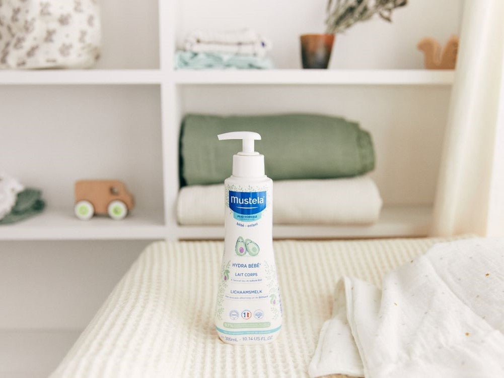 Mustela Hydra Bébé, pump bottle on a changing mat by nursery shelves