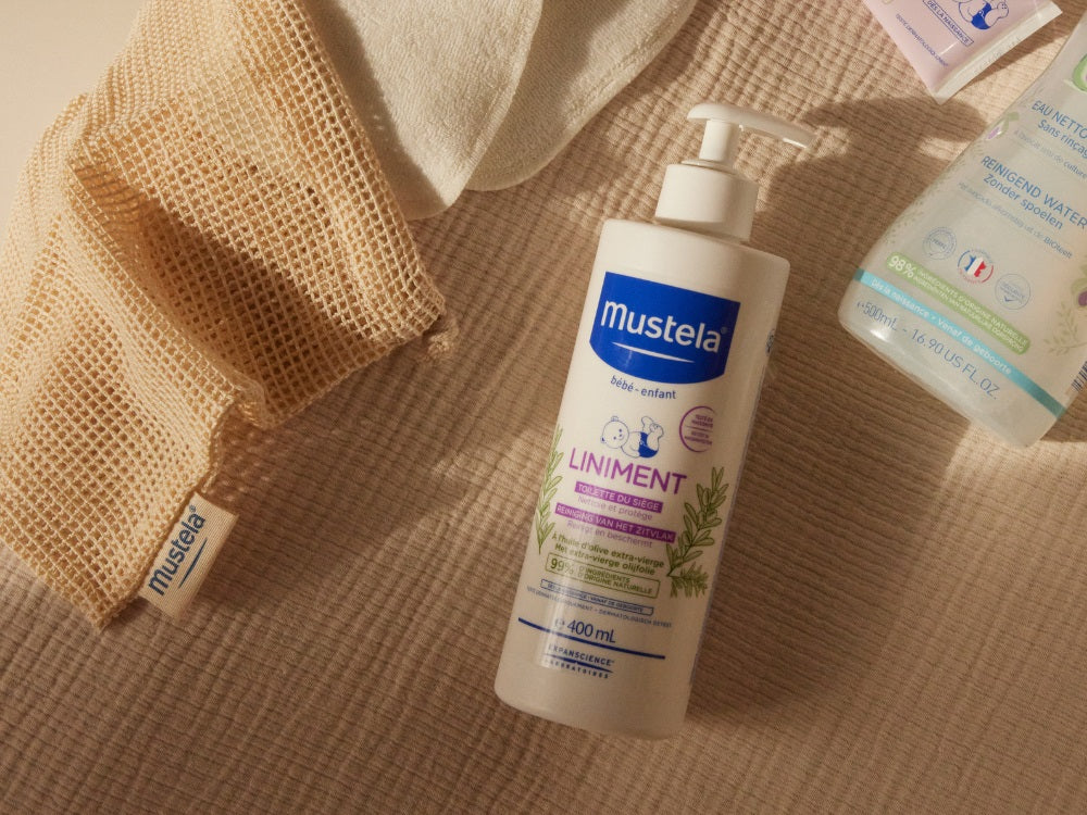 Mustela Liniment, pump bottle on a muslin cloth with a mesh bag