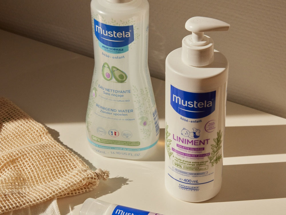 Mustela Liniment, pump bottle beside a cleansing water bottle on a shelf