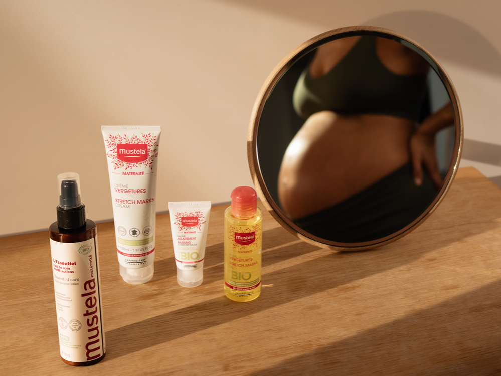 Mustela Multi-Action Milk, Maternity range of four products by a round mirror