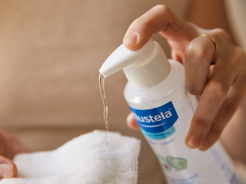 Mustela No-Rinse Cleansing Water, pump bottle dispensing onto a white cloth