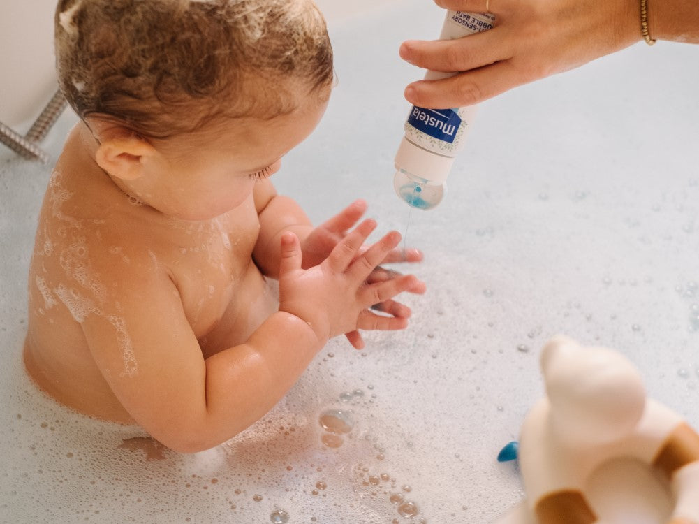 Mustela Foaming Bath, baby in a bubble bath as the bottle is poured