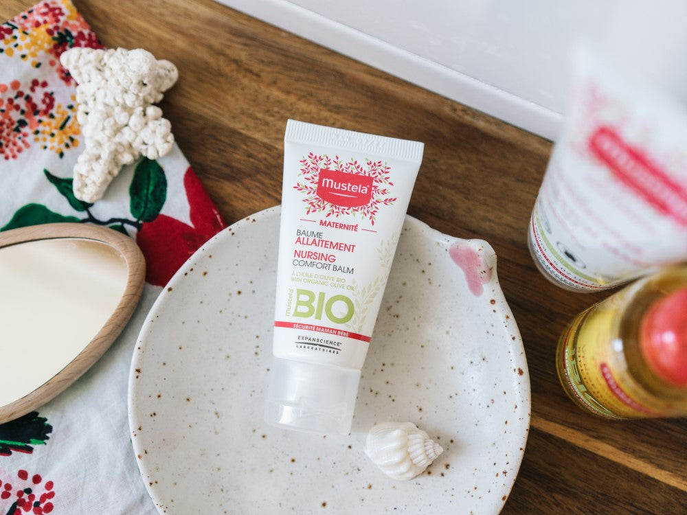 Mustela Organic Nursing Balm, tube on a speckled plate with a seashell