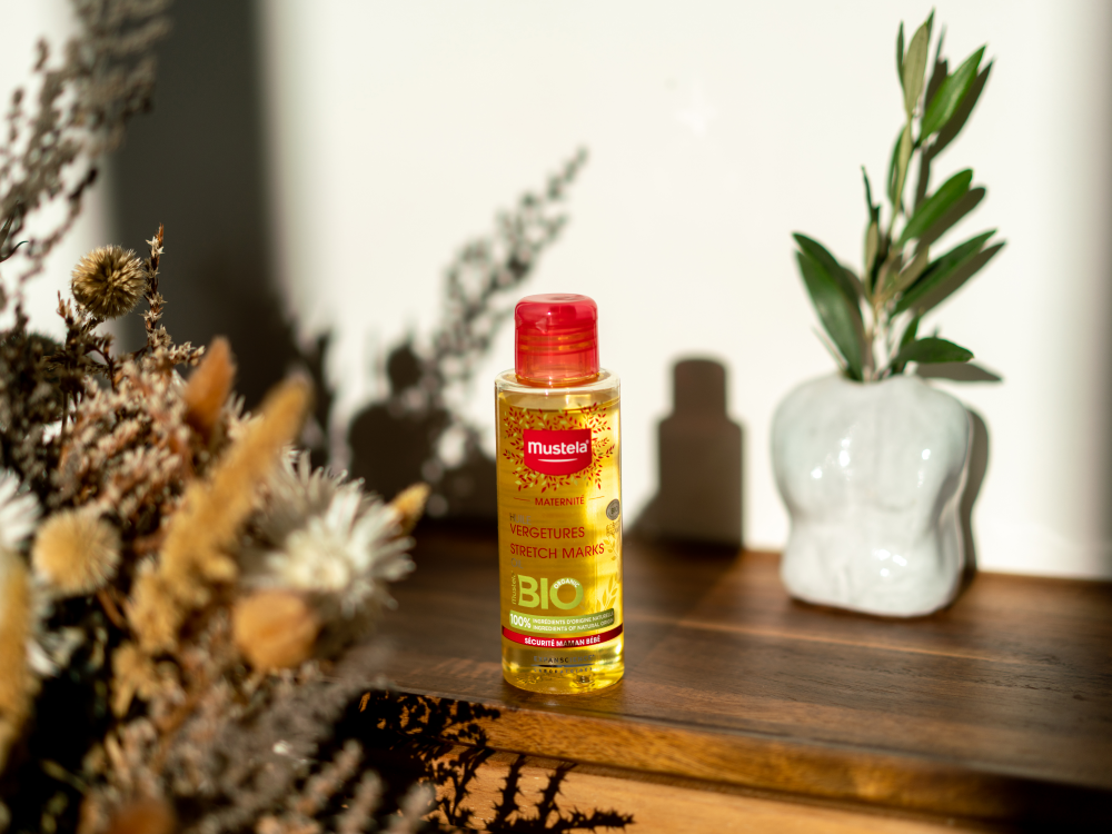 Mustela Maternity, bottle on a wooden shelf with dried flowers