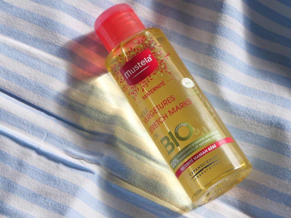 Mustela Maternity, bottle lying on striped fabric